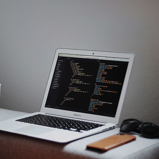 Dev Tech Solutions | an image showing a white macbook air with a screen of code