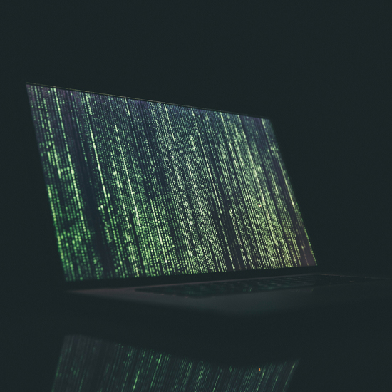 Dev Tech Solutions | showing a variety of green code on a laptop display