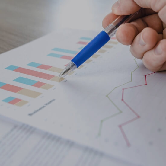 Dev Tech Solutions | Laptop showing performance data and charts while a person reviews analytics at a desk.