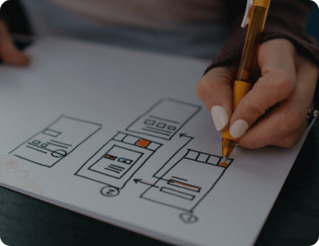 Dev Tech Solutions | Person sketching a website layout and page structure on paper during the early planning stage of a website build.