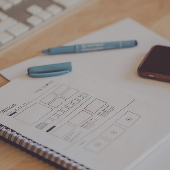 Dev Tech Solutions | Wireframe sketches of a website layout showing form and content structure on a notebook.
