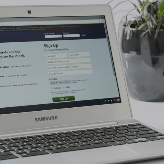 Dev Tech Solutions | Person filling out an online sign-up form on a laptop in a clean workspace.