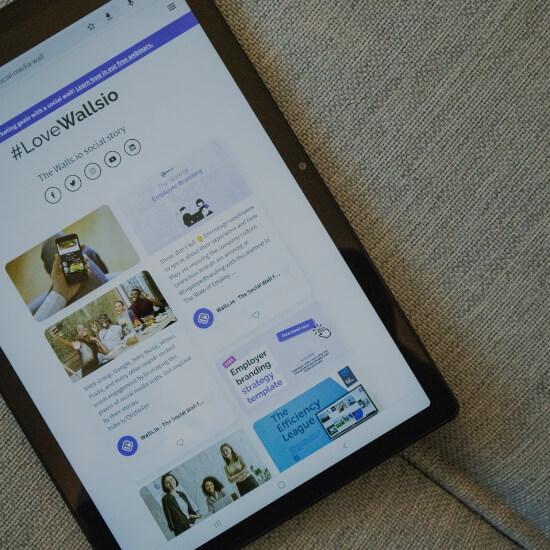 Dev Tech Solutions | Tablet displaying a clean, card-based website layout resting on a sofa.