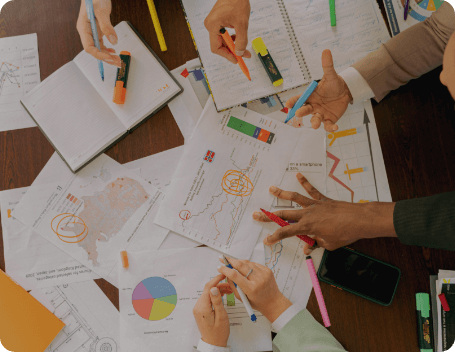 Dev Tech Solutions | Team analysing printed analytics reports and charts together during a website performance review.
